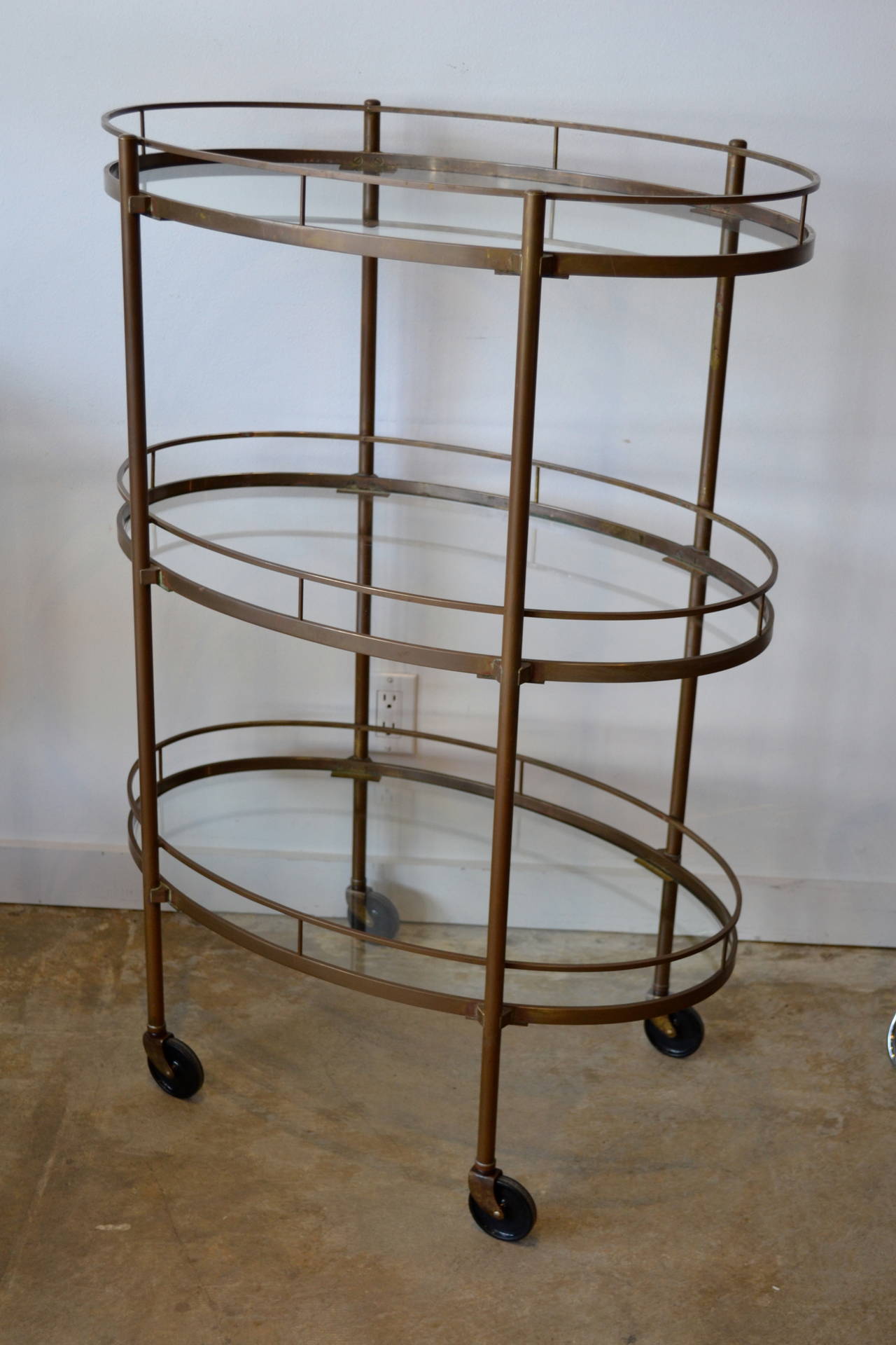 Exceptional three-tiered, Art Deco, solid brass serving cart with refined lines and original glass by Maxwell Phillip Co, 1930s. This cart is in excellent condition, all original with original patina. Can be shined to high polish if desired.