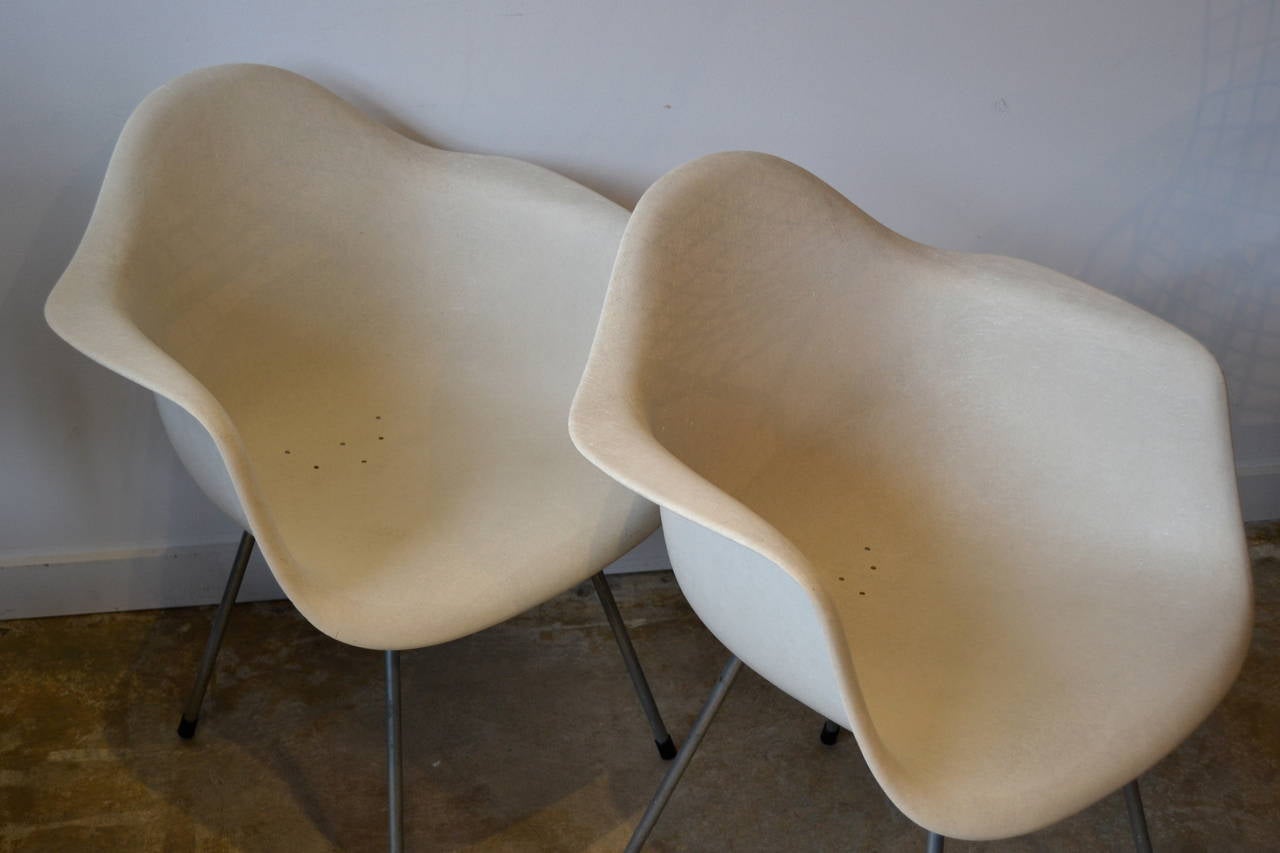 Pair of early production Eames Zenith chair manufactured by Herman Miller. Matte fiberglass shell construction. Holes in seat for ventilation.