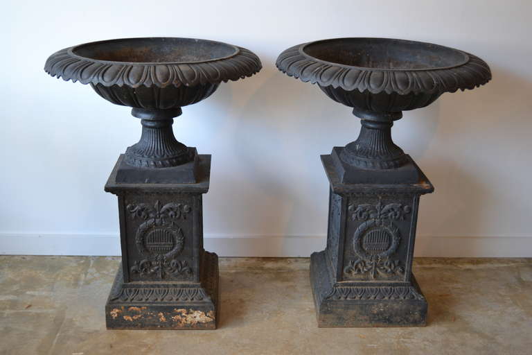 stunning pair of cast iron garden urns in original condition.  two piece, base and plant tub.