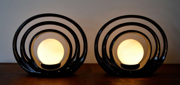 Very cool pair of table lamps, white glass sphere surrounded by three black halos.