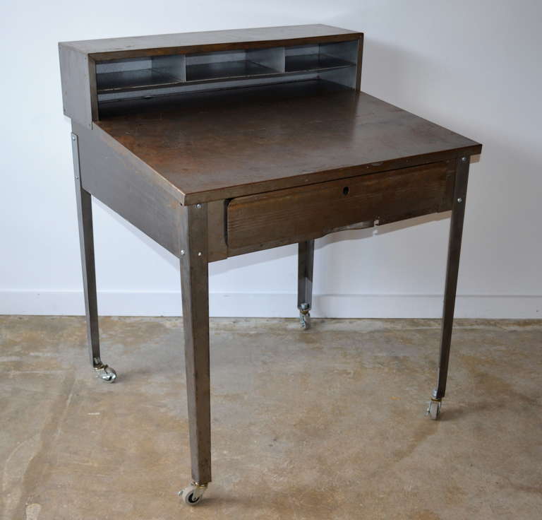 Vintage metal postal service desk on casters, removable shelf.