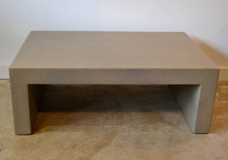 Sleek small rectangular plaster on wood coffee table with a slight textured finish.