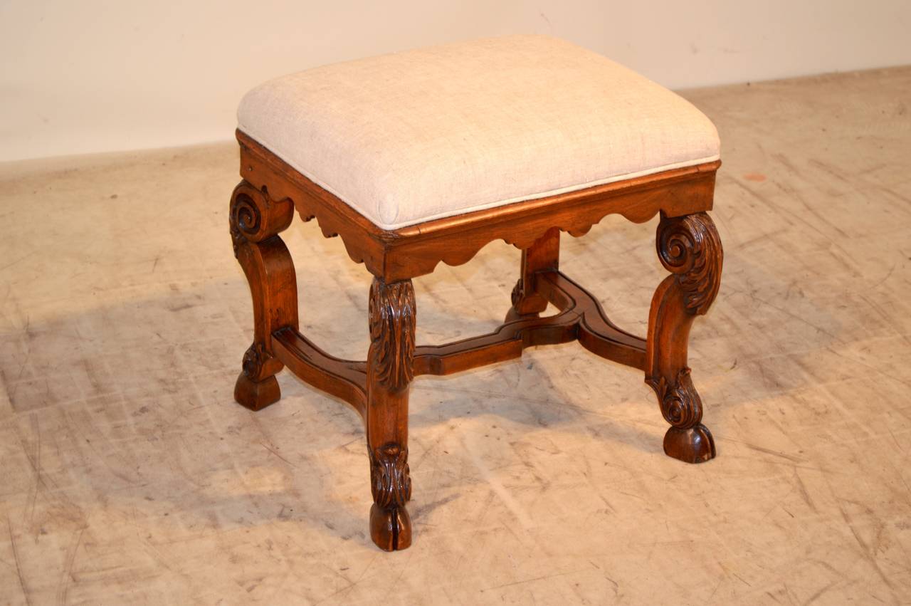 19th-c. English walnut stool with scrolled cabriole legs with hand-carved acanthus leaf decoration on knees. It has a wonderfully scalloped apron, following down to gracefully formed legs with acanthus leaf carving decoration on the base of the