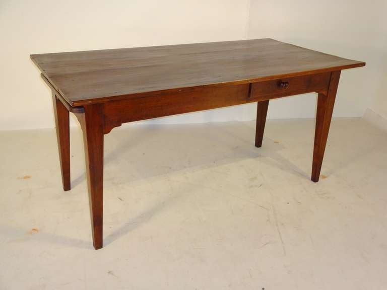 18th-C. French walnut kitchen farm table with a plank top, single drawer and a bread board extending from one end of the table. Resting on tapered legs. Apron measures 24.25