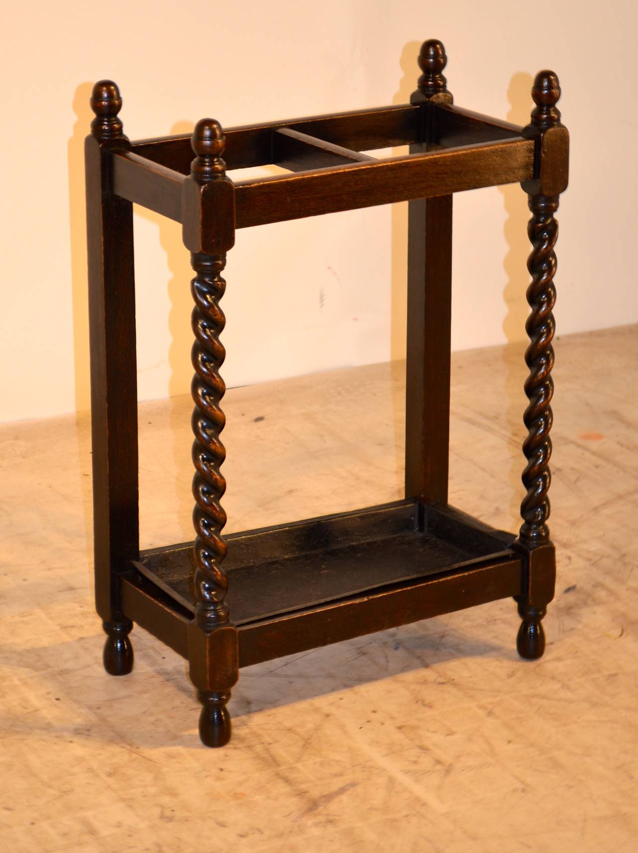 Late 19th century, English oak umbrella stand with lovely hand-turned finials and barley twist front legs and simple back legs. Metal tray shows signs of normal wear. Nicely turned feet.