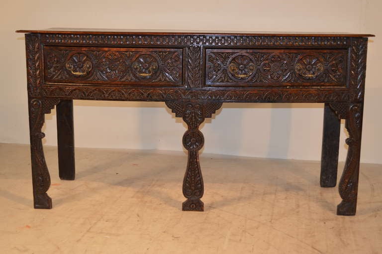 17th-C. English oak Charles II sideboard.  The top has a beveled edge, following down to a carved front with two drawers and vase shaped legs, which are also exquisitely carved.  The case is dovetailed construction, and has simple back legs.