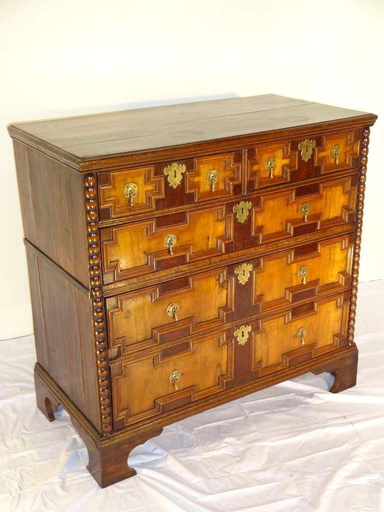 Mid-18th-C. English geometric chest. The case is made out of English oak with lovely walnut paneled drawer fronts.  The two tone contrast of this chest is unusual.  Beaded molding adorns both sides of the case. Resting on bracket feet.  Case was
