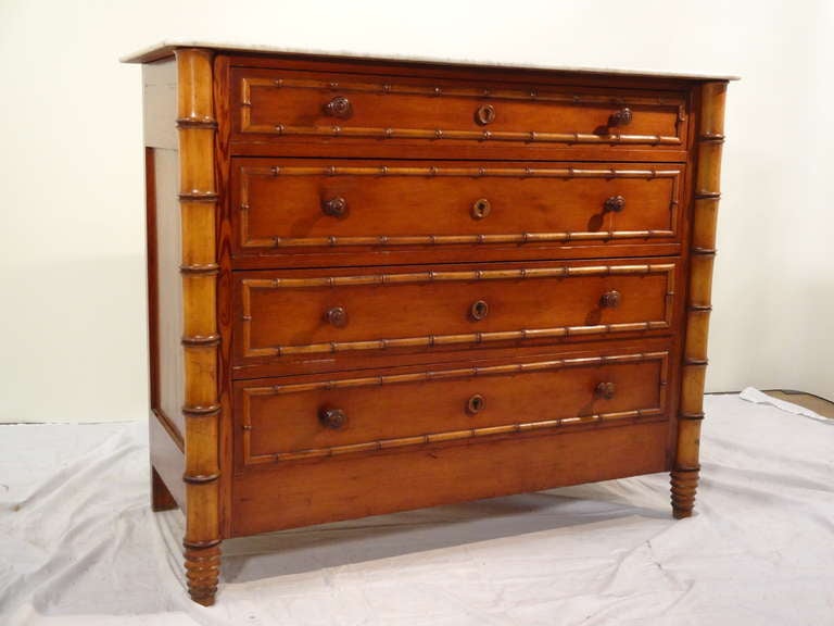 19th-C. French faux bamboo chest of drawers.  The front of the case is made of cherry and the sides are pitch pine and paneled.  It retains its original white marble top.  The drawer fronts are decorated with faux bamboo molding and the