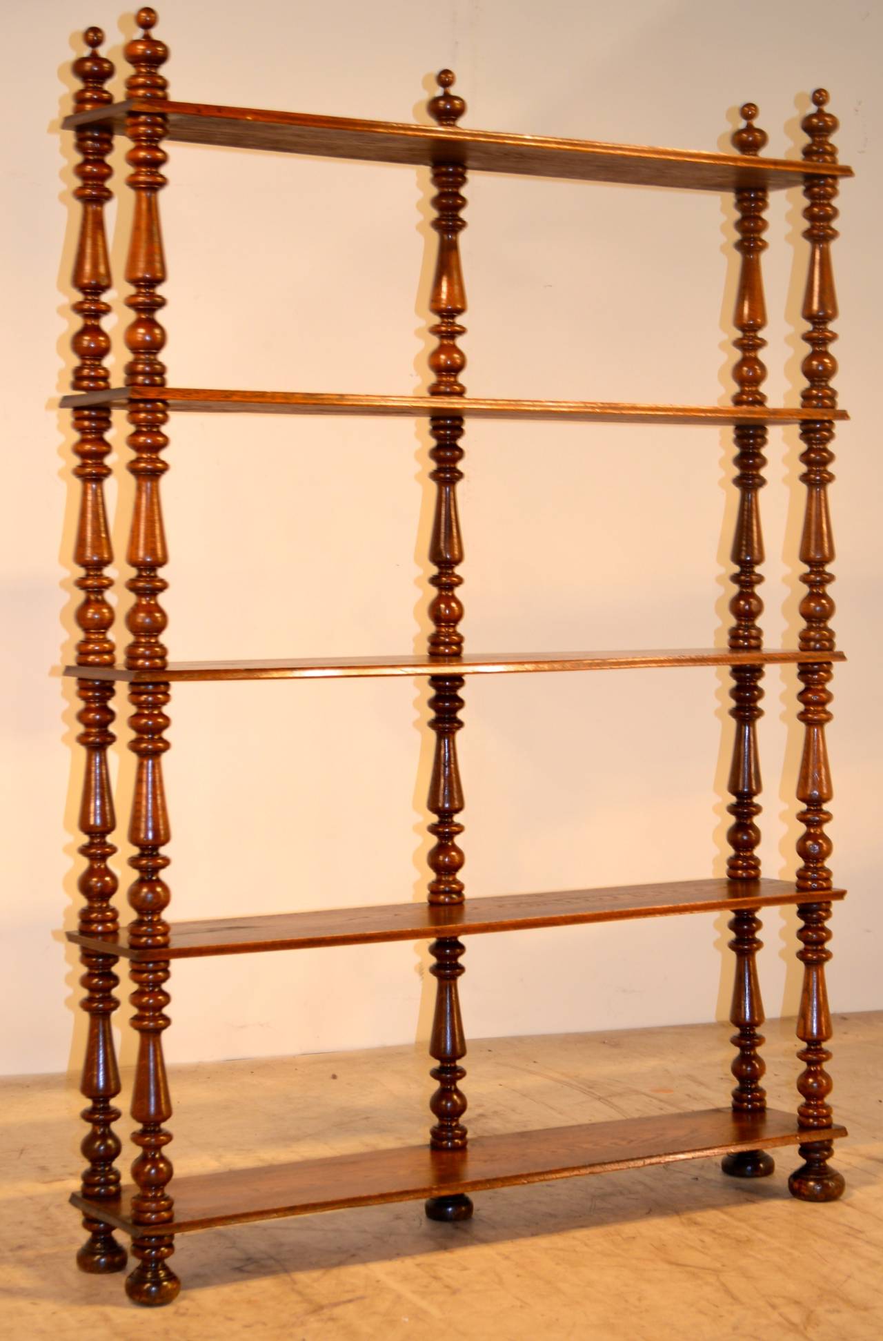 Mid-19th-century English narrow mahogany étagère. The shelves have beveled edges and are separated by turned shelf supports.