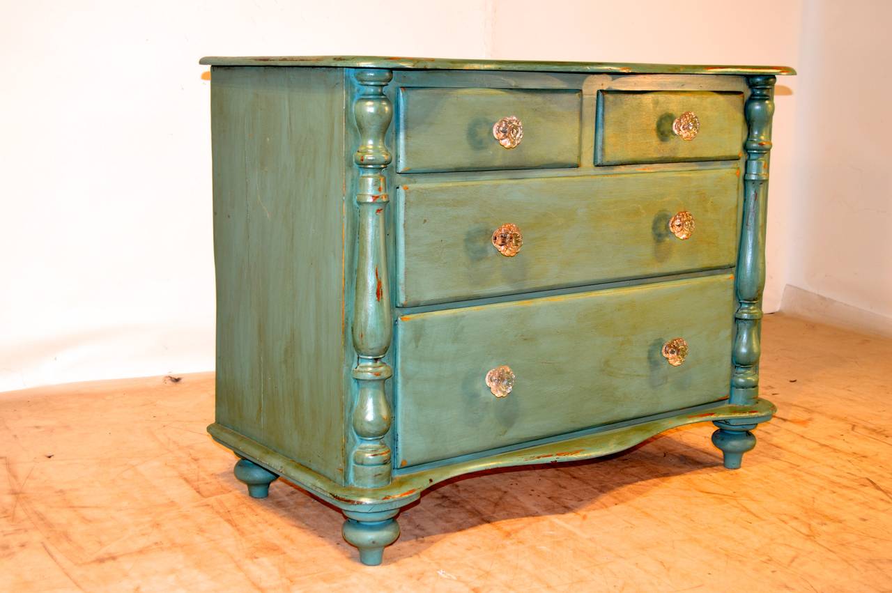 19th-C. English pine chest of drawers with a serpentine shaped top, following down to two drawers over two drawers, flanked by half columns on both sides. The bottom of the chest mirrors the top with the serpentine shape and is raised on turned feet.