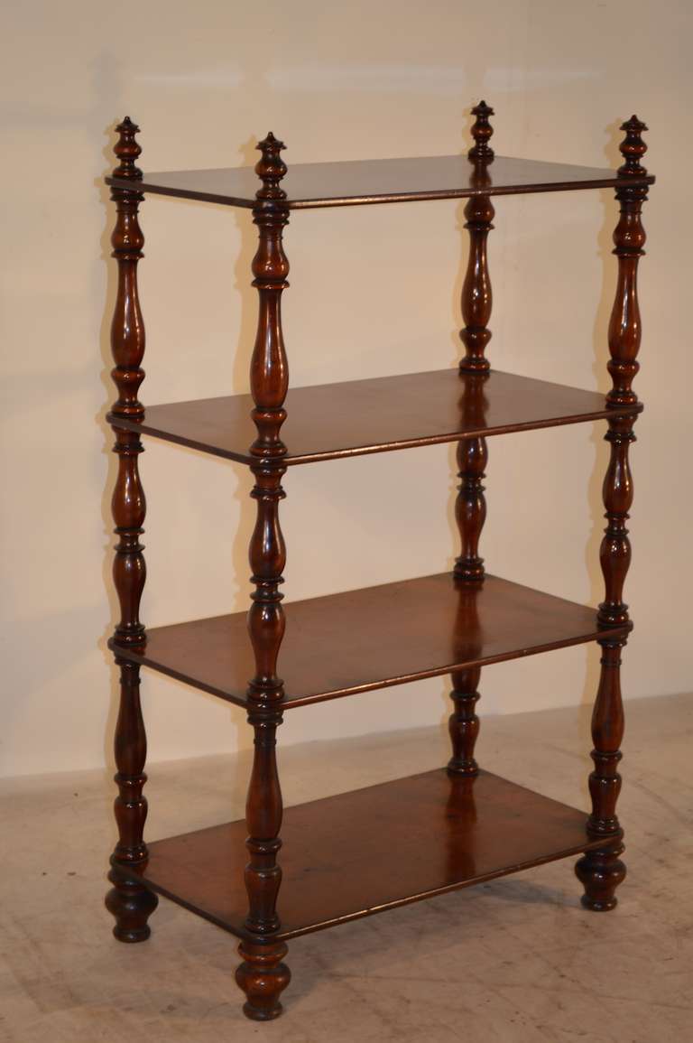 Mid-19th-century English mahogany shelf. There are four shelves, separated by wonderfully turned shelf supports. Resting on turned feet.