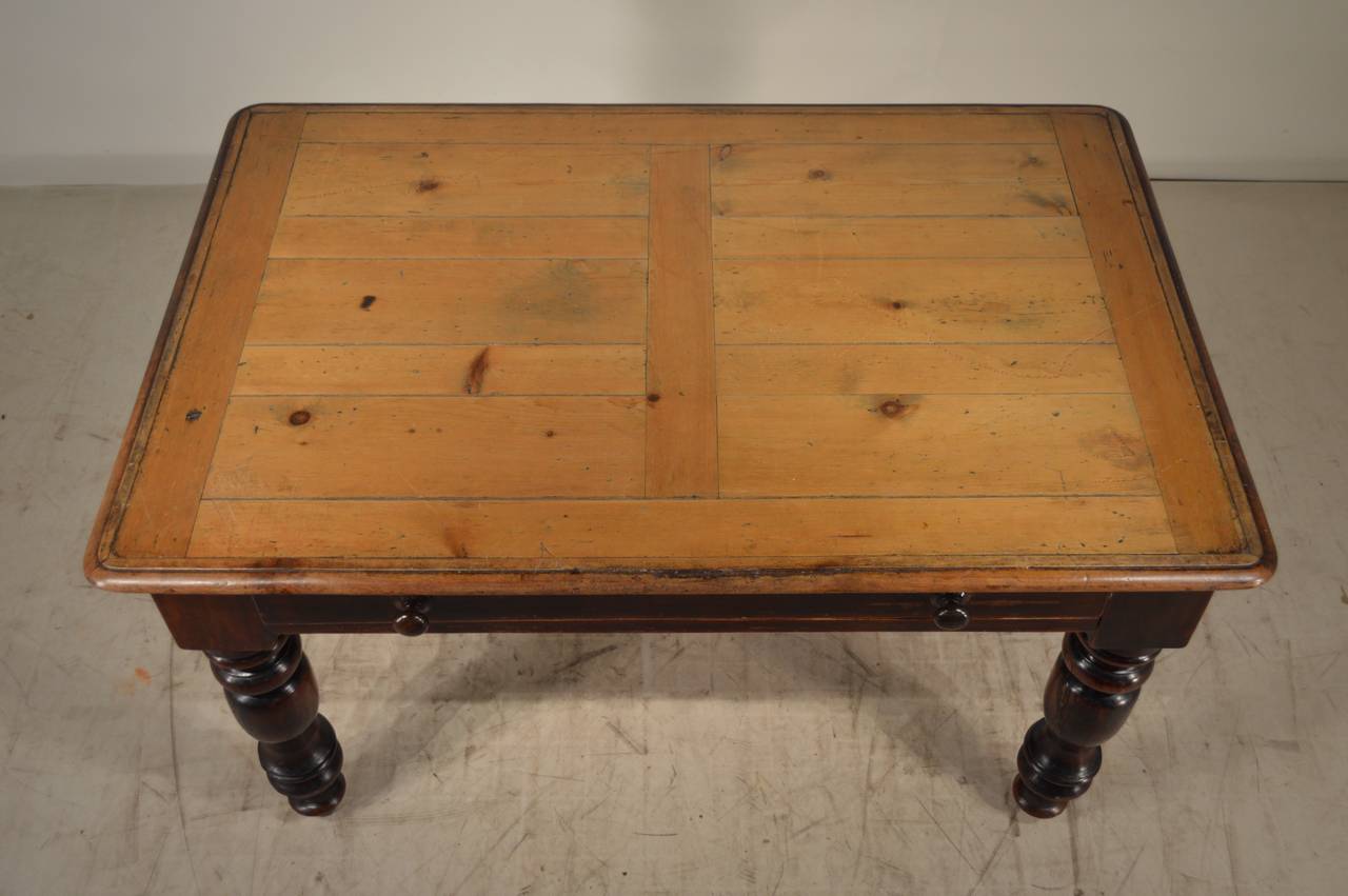 19th century English pine farm table with a plank designed top following down to a wonderfully constructed base with thickly hand turned legs and a large single drawer.  Scratches on top from use.  Apron measures 23.75