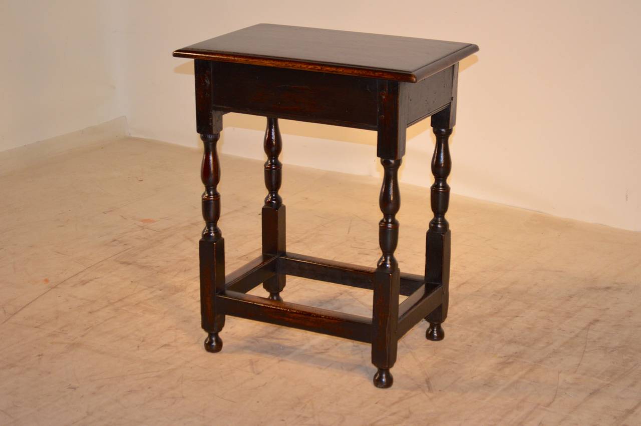 Period William and Mary English oak side table, circa 1720, with pegged construction and a beveled edge around the top, following down to a simple apron which contains a single drawer. The legs are hand-turned and are connected by stretchers. Raised