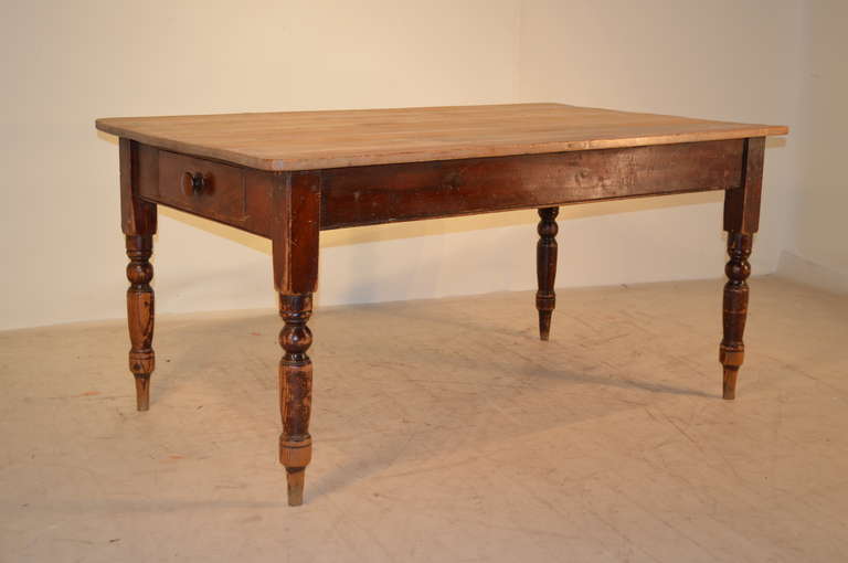 19th century English pine farm table with a plank top, following down to a simple apron with a single drawer and nicely turned legs. Apron, 23