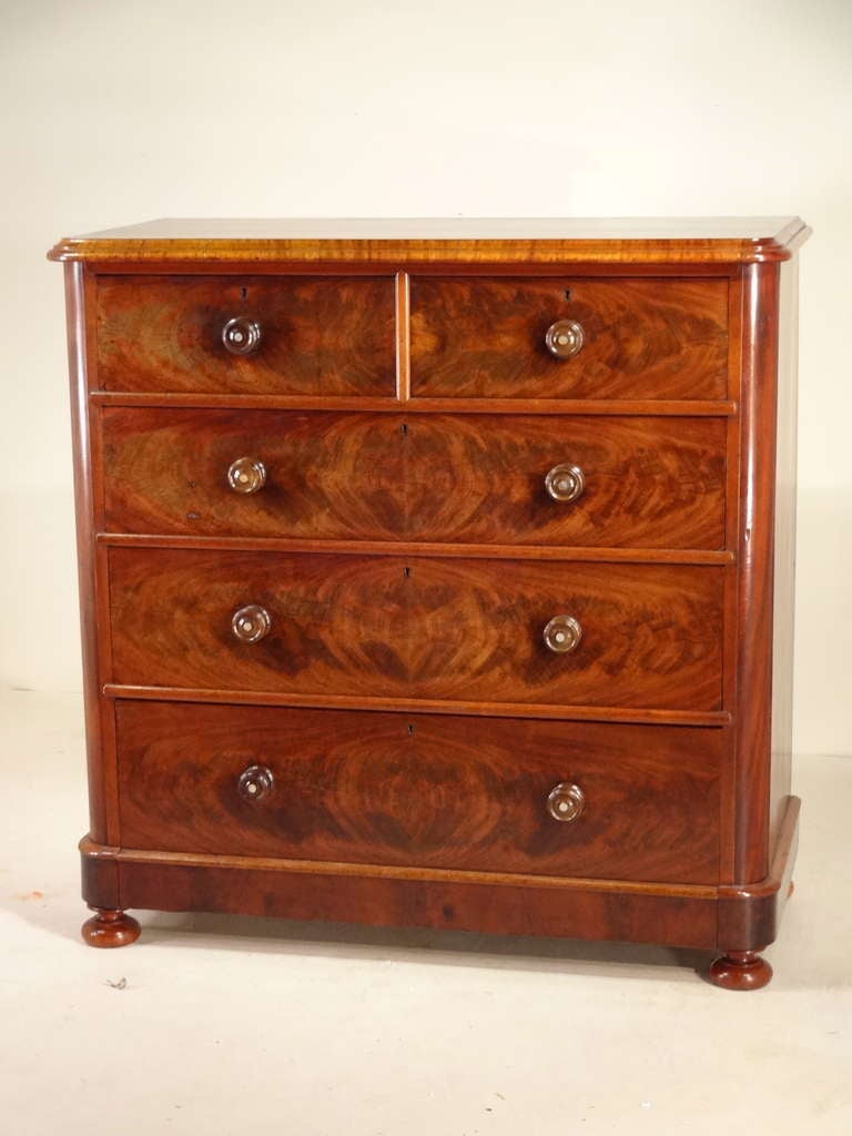 Wonderfully grained top with beveled edge, following down to two drawers over three drawers with fantastic graining on the drawer fronts. Supported on bun feet.