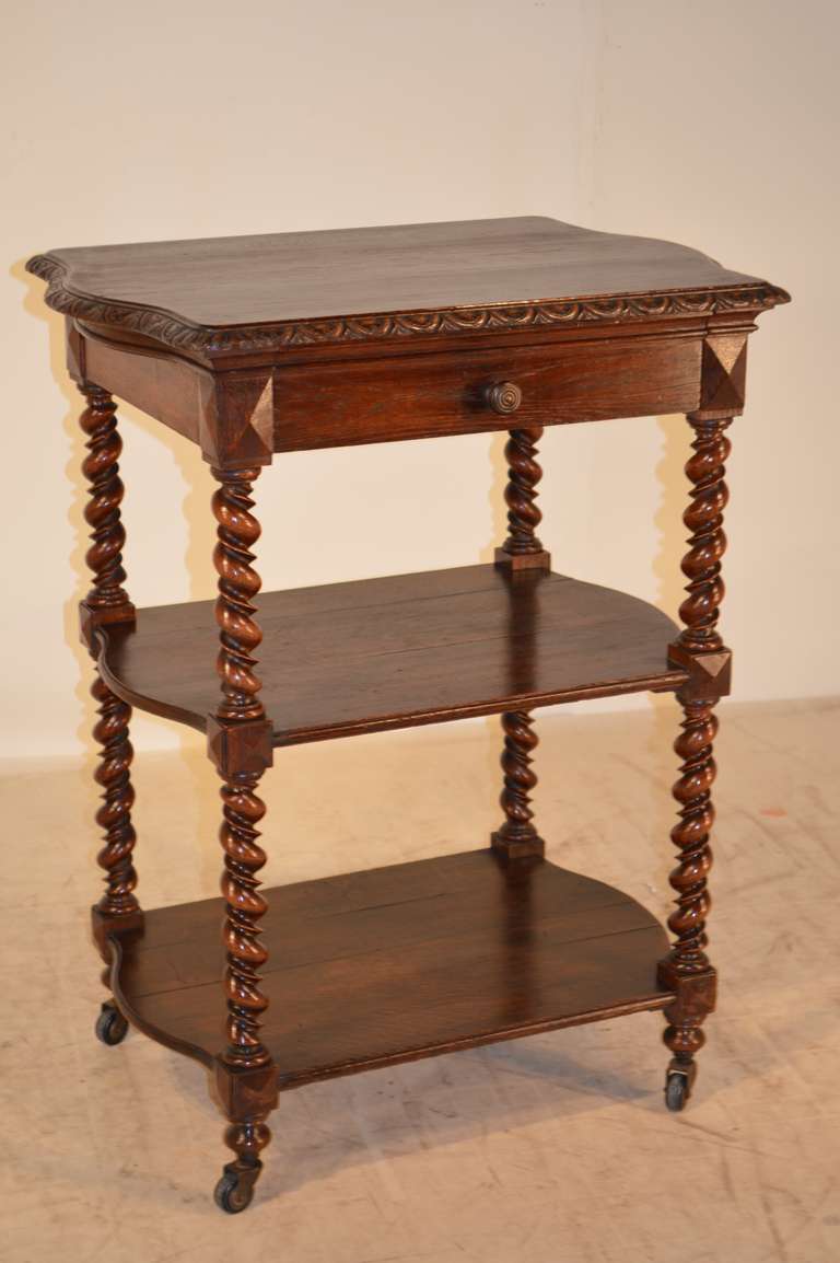 19th-C. French oak dessert buffet.  Fantastic size for any room setting!  The top has a beveled and gadrooned edge around the serpentine top following down to a single drawer over two shelves, separated by wonderfully hand turned vine twist shelf