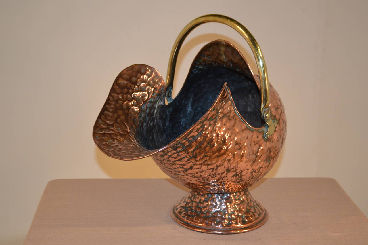 19th Century English coal hod made from hand-hammered copper. It has a fantastically Silhouetted shape and handmade brass handles. The handle on the back has heart shaped accents.