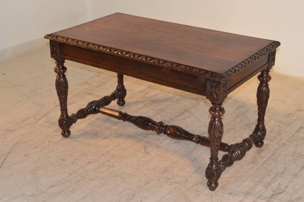 19th century French coffee table made from oak. The top has a beveled and hand-carved decorated edge, following down to a paneled apron and supported on hand-turned and carved legs and stretchers. Raised on turned feet.
