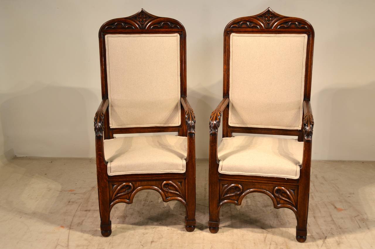 19th century pair of English armchairs in the gothic manner. They have wonderfully carved frames and are newly upholstered in linen with a double welt decoration. Seat measures 18.25