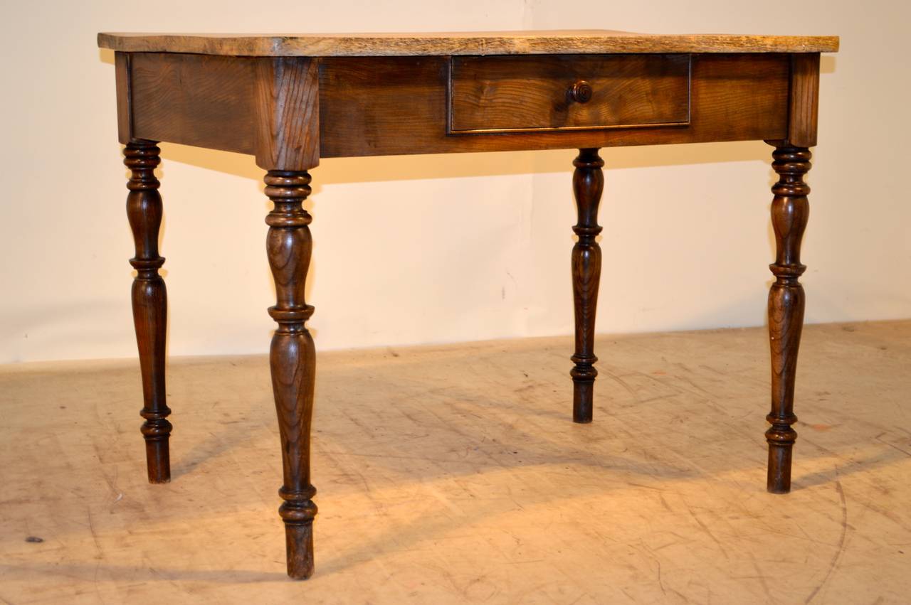 19th-C. French farm table made from elm. It has a scrubbed elm two-plank top, following down to a simple apron containing one drawer over turned legs.