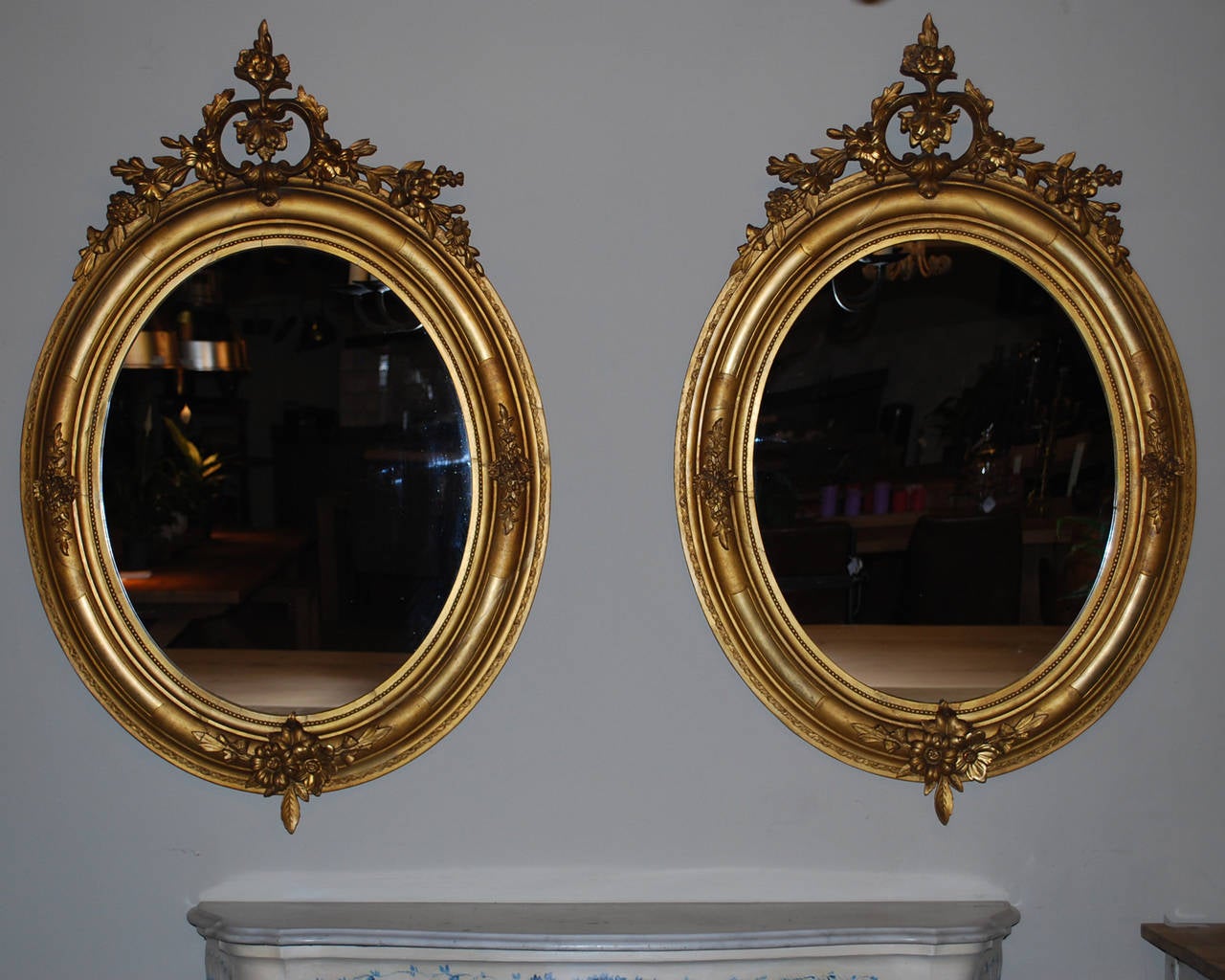 Pair of gold gilded oval mirrors with floral ornaments on the frame and in the corniche. New glass.
Originates in the south of France, dating app. 1850.