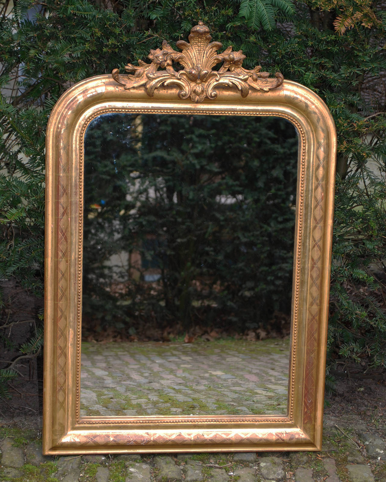 Small antique French mirror.
Louis Philippe with an ornate crest.
The central molding is incised with a cross motif.
Completely gold leaf gilded.
Original gold, Original glass with minor wear.
Originates south of France, dating app. 1860