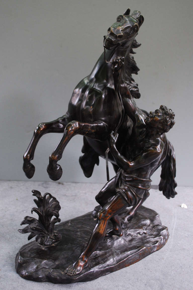 This stunning antique bronze was based on the massive Marly Horses marble statues in France. Originally commissioned by King Louis XV in 1739, and carved by Guillaume Coustou, the statues remain standing today. From the outset, Coustou's horses were