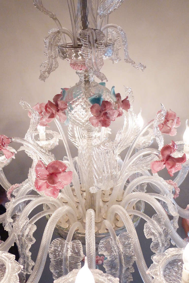 Schöner großer venezianischer Kronleuchter mit rosa Blumen und blauen Blättern. Er zählt 12 Lichter. Dieses handgefertigte und mundgeblasene Glas ist reichhaltig verziert und atemberaubend detailliert.