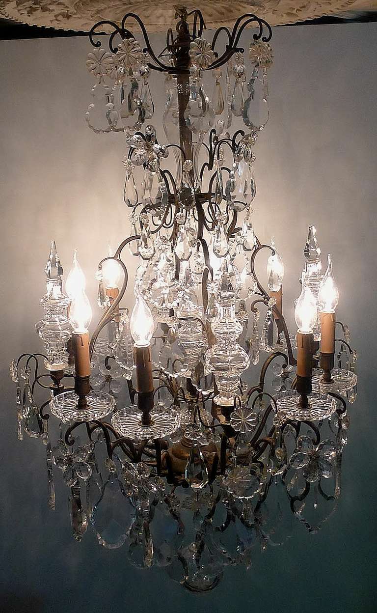 Rich chandelier hung with many crystal ornaments and crystal peaks.
This lamp contains twelve lights, eight on the outer circle and four at the bottom.
Originates France, dating circa 1850.