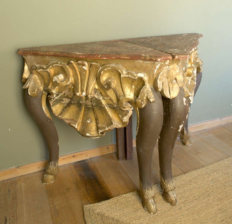 A set of four italian giltwood and marbelized corner consoles