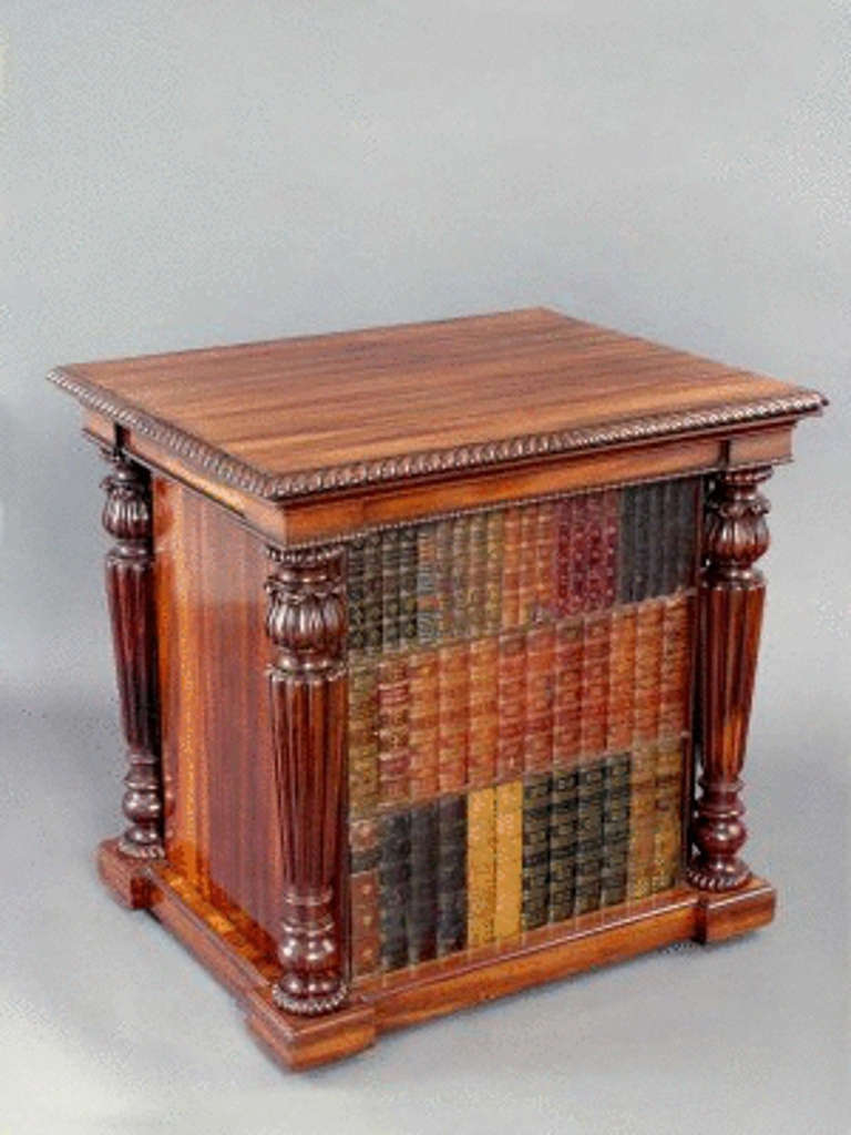 A magnificent and important Folio Cabinet of Goncalo Alves, formed as a centrepiece with horizontal dividers on one side and an arrangement book spines on the face. These are flanked by four beautifully carved columns below a sliding and rising