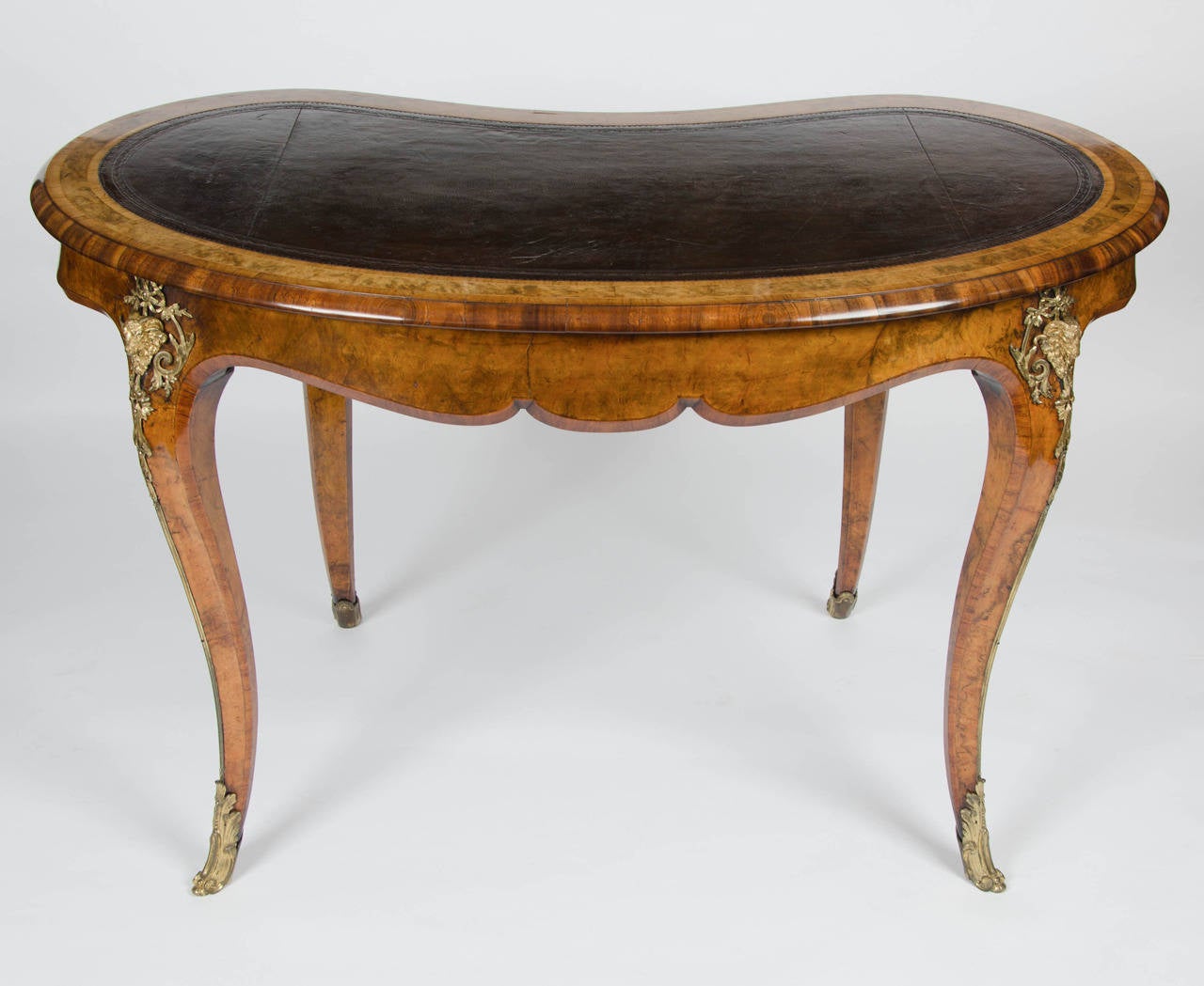 A wonderful kidney shaped writing table with single drawer stamped by Gillow & Co. 
The finely figured burr walnut crossbanded throughout and with fabulous rams head ormolu mounts. The top with original inset leather.
Of typical fabulous quality