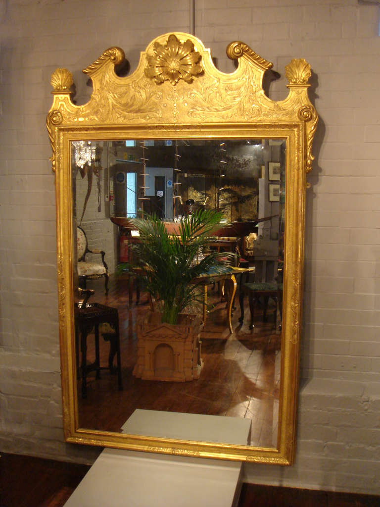 A wonderful and rare pair of early 20th century carved and gilt wood mirrors.