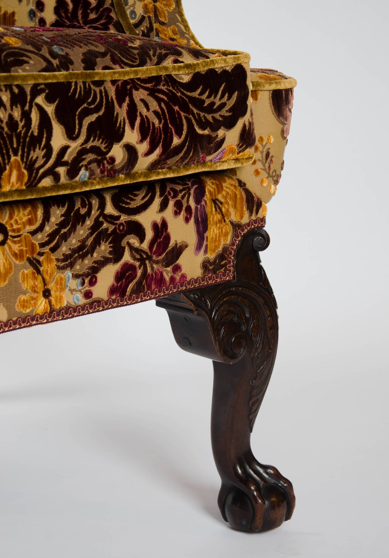 An exceptional quality 19th century wing chair of fine 18th century proportions. Cabriole legs front and back; the profusely carved front legs with claw and ball feet, the back with C-scroll detail and pad feet.
