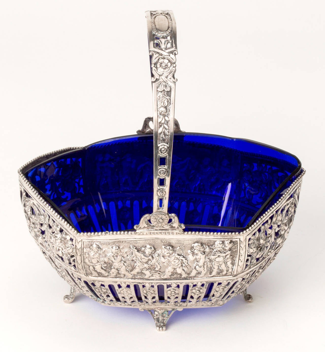 Continental 835 Silver pierced basket with handle.  Decorated with reposse of cherubs  around the basket.  Original cobalt blue glass liner.  C. 1900s