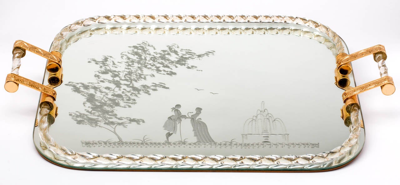 Fabulous and large Murano tray with gilt and glass handles. The tray is bordered by a Venetian twisted glass gallery. The tray itself is mirrored, etched with a scene of a romantic couple. Great as a dressing table tray. Or gallery bar tray.
There