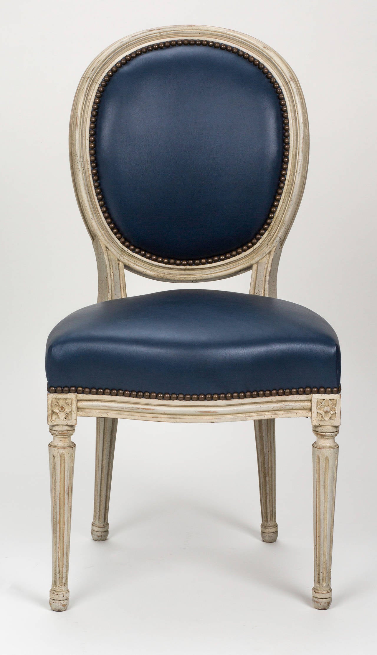 Pair of 1880s French Louis XVI style chairs. Lovely antique painted finish, newly upholstered in Edelman's leather. Finished in antique brass nail studs.