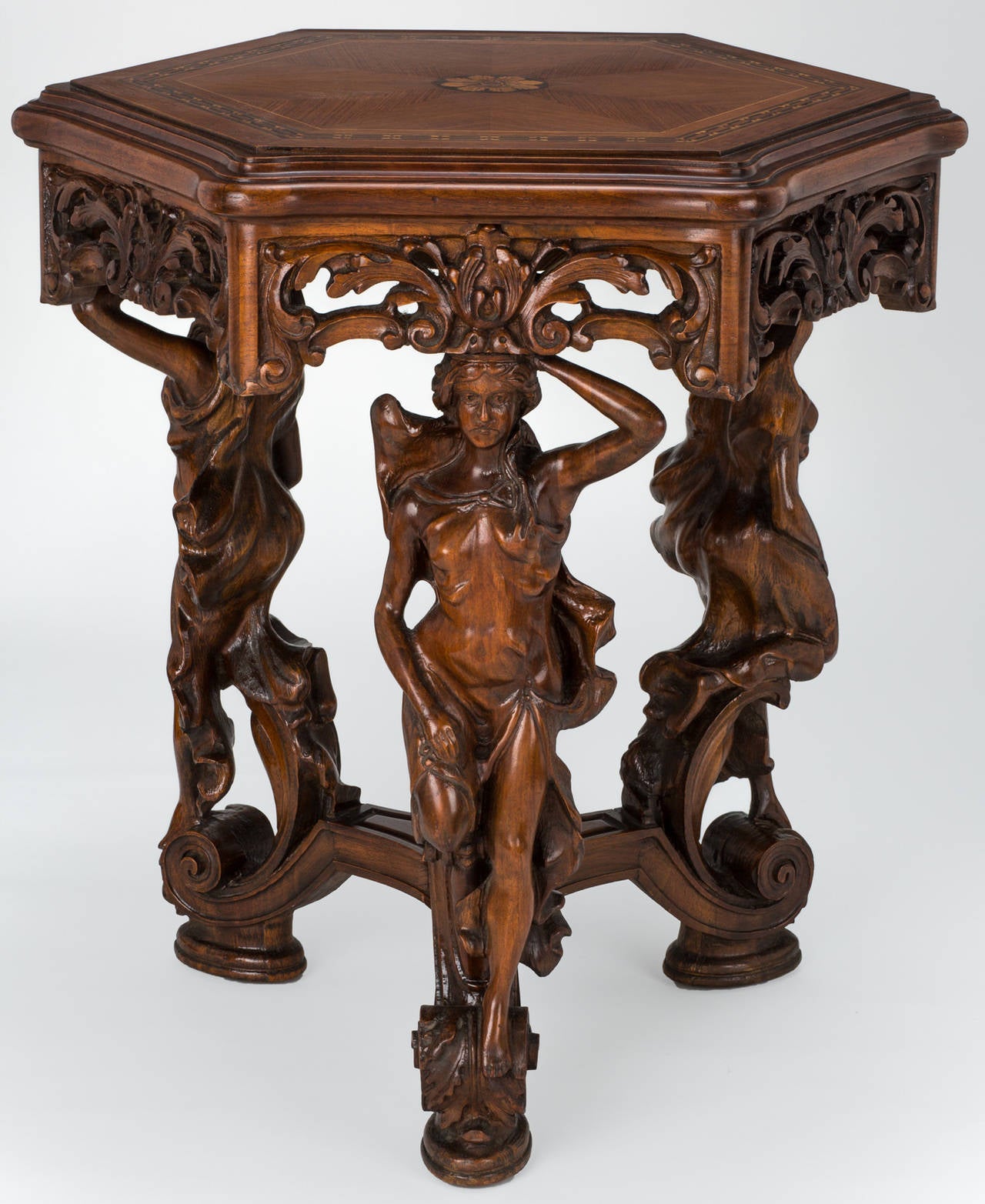 Art Nouveau, hexagonal shape table with intricately detailed marquetry top. The table is supported by beautifully carved female figurines in mahogany wood.