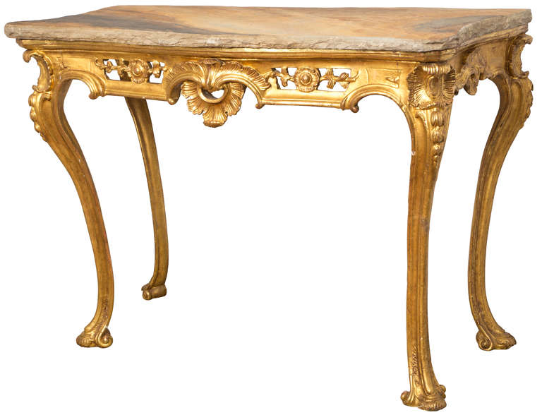 Exquisite, 1860s Italian gilt and carved wood console table juxtaposed with very contemporary stone top.  Important unusually large scale.  Carved wood with exceptional gilding  work.  Stone top is cut to look natural with rough edges.