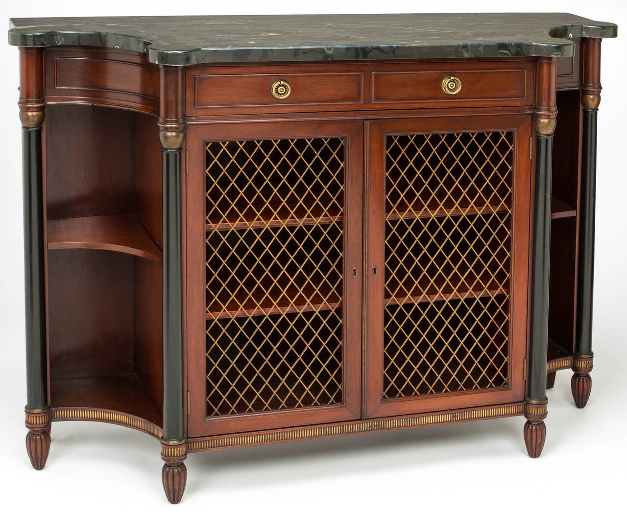Pair of Mahogany wood cabinets with ebonized wood posts and gilt work.  Original  black marble top.  Bowed shaped front with pair of drawers and cabinet doors in bronze grill with interior shelvings.  Sold as a single piece  or as a pair.