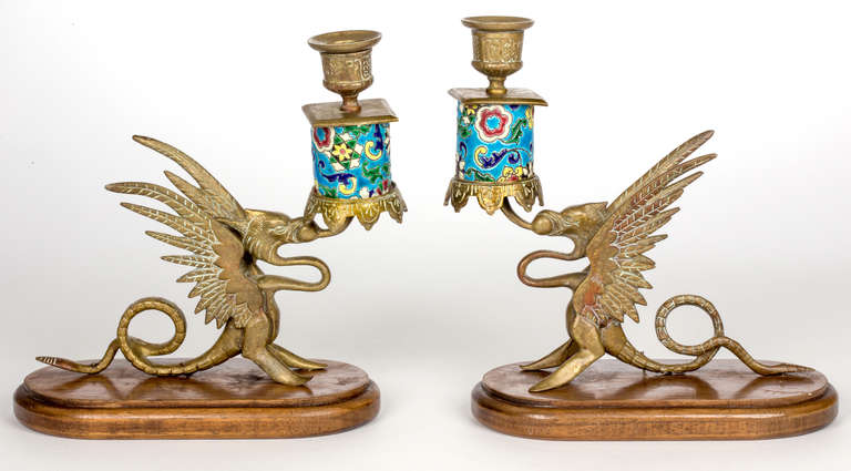 Beautiful and colorful pair of French Longwy candlesticks.  
Griffin motif with colorful enamel work for candles.  It sits on wooden plinth.