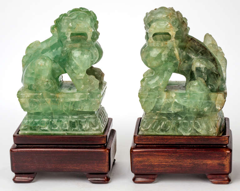 C. 1930s Carved foo dogs or lions in  Fluorite stone of beautiful green coloration.  They sit on a carved Rose Wood stand.
