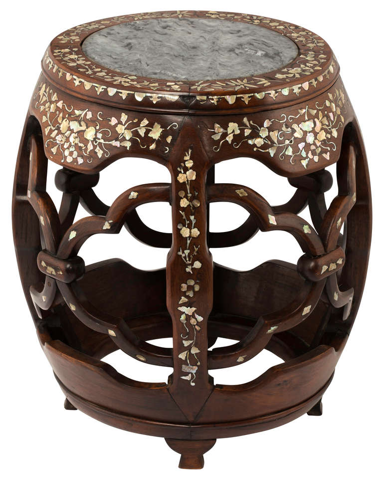 Beautiful round carved rosewood table stand with stone top.  Barrel shape with intertwining carvings with intricate mother of pearl inlay.  Wonderfully useful for a side table or plant stand.