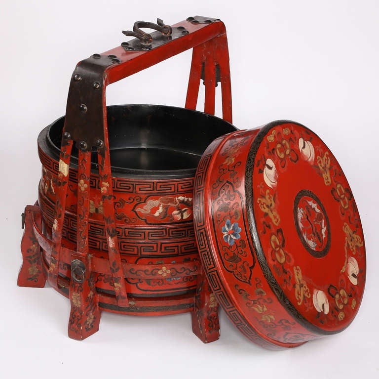 Festive red stacking lacquer boxes are used for carrying food on the wedding procession of the bride. Usually there are two sets of boxes to balance each on the end of the pole. The top round box serves as a lid for the bottom box and has a lid of