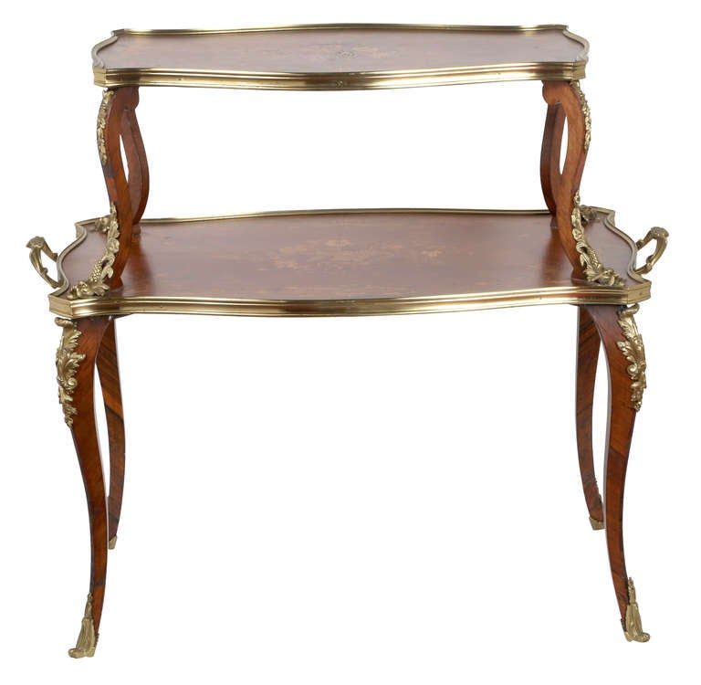 Graceful and beautiful Fruitwood marquetry two tier server table. Set with exquisitely cast bronze dore fittings from the 1870s.
It is in excellent condition.