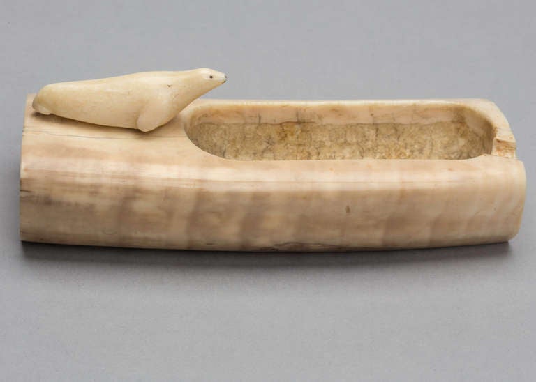 Alaskan folk art.  From the early 1900s.  Carved ashtray from walrus ivory. Carved  seal sitting on the tray.