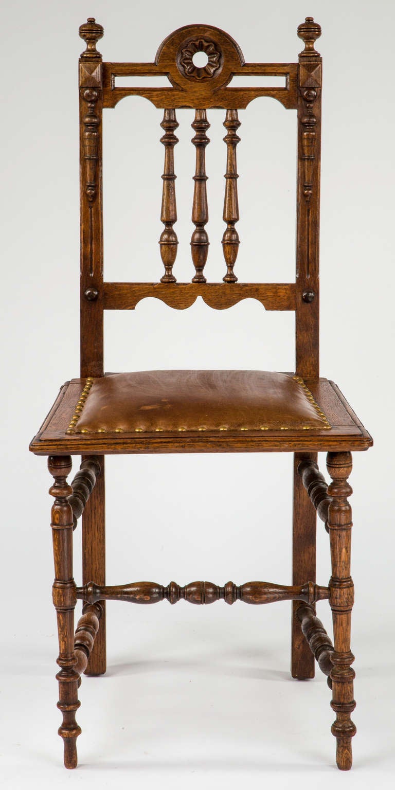 Pair of early 1900s chairs. Beautiful turned legs and details. Originally seats were done in cane. Replaced with new upholstery in leather and antique brass studs. Very comfortable and sturdy.