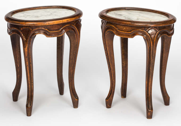Circa 1930s, small and sweet pair of oval round walnut tables with marble top. Nice pair for side cocktail  tables. Graceful cabriole carved legs.