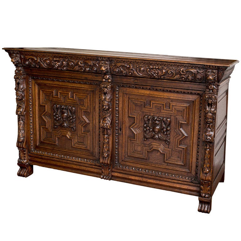 19th century beautiful and dramatic buffet sideboard from Bruges (Brugge), Belgium. Made from solid dark European oak. Door panels and drawer fronts are fantastically carved with great details. Behind the doors is ample room for storage with one