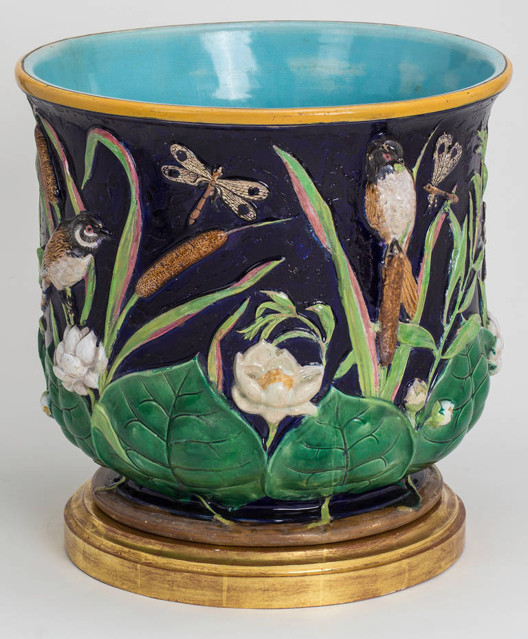 Pair of the most fantastic Majolica jardinières with most beautiful colorations. Depicting charming whimsical birds, insects and flora. It sits on custom-made contemporary wood gilt plinths. The plinth is 14.25